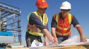 Men looking at building plan infront of steel frame